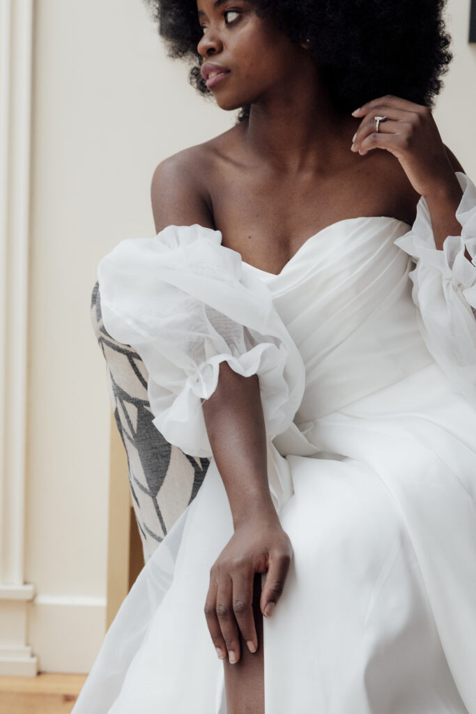 Image of a bride sitting in a puffy sleeve wedding dress 