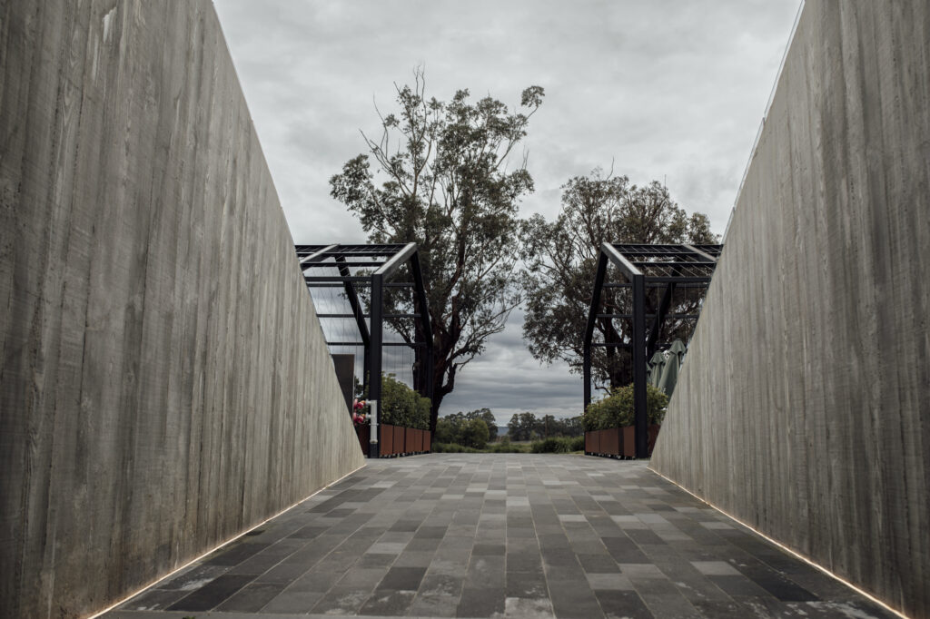 Guests start to walk down the grey black concrete buildings and enter the cellar door, greeted by high walls and a sculpture of the famous stag protruding.