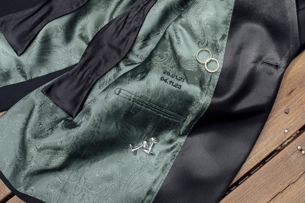 A shot of the Suit from Oscar Hunt. The black jacket is lined with green satin and embroidered with their names.