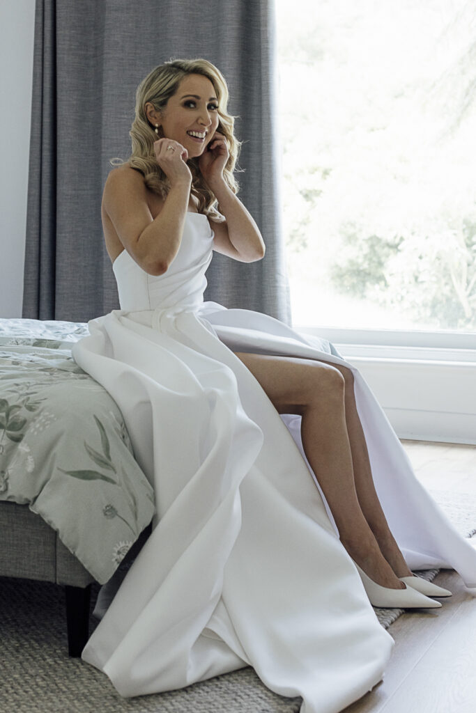 Bride getting ready at home, in a gorgeous ivory gown from Mariana Hardwick.