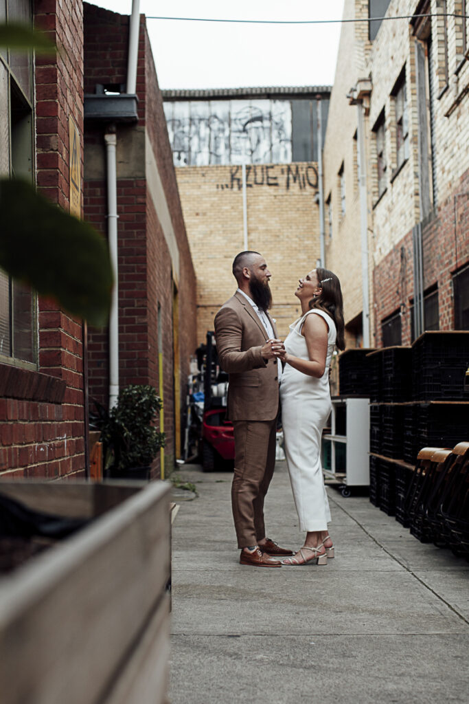 Bride and groom in an laneway in Melbourne dancing and laughing