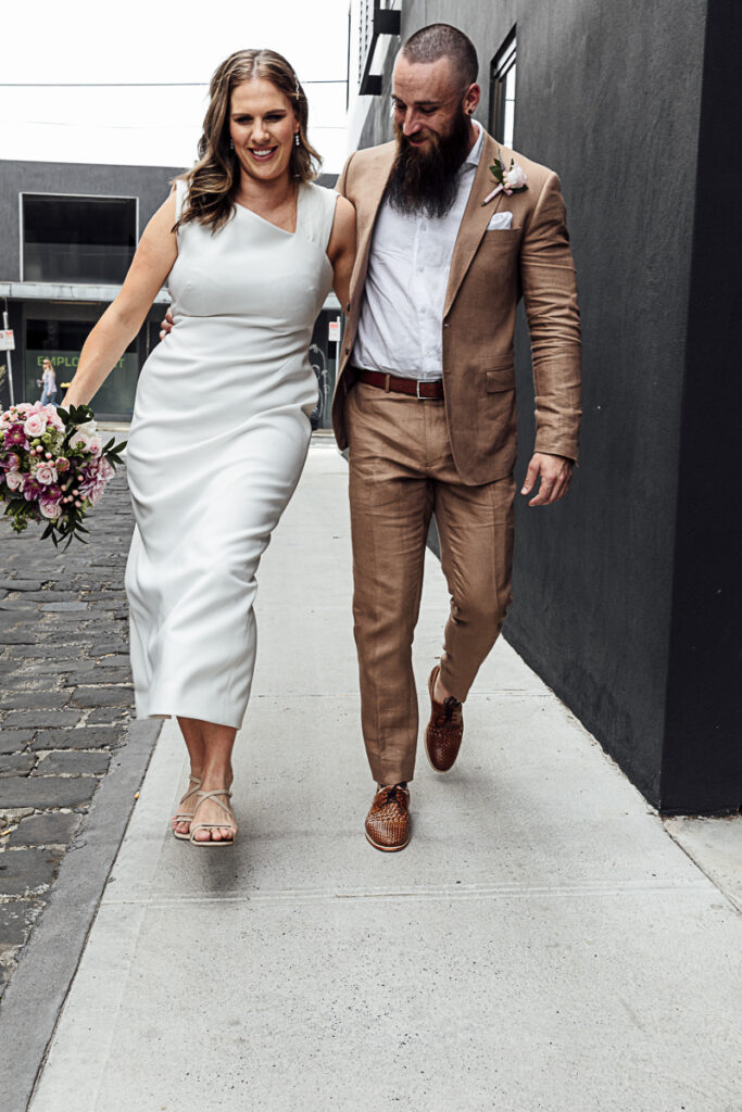 Bride and groom in an laneway in Melbourne dancing and laughing