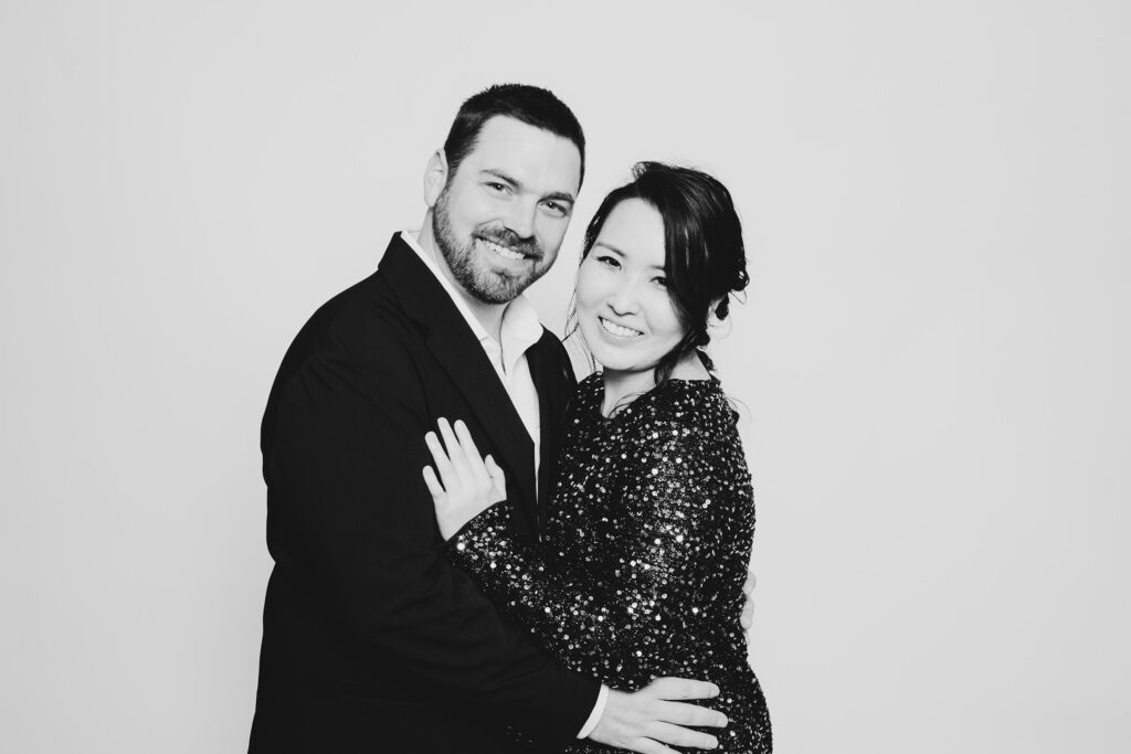 A black and white photo of a couple dressed in formal wear having fun and having a photo taken