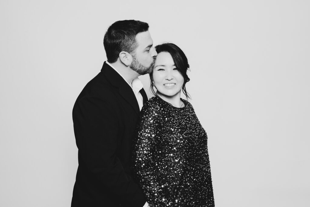 A black and white photo of a couple dressed in formal wear having fun and having a photo taken