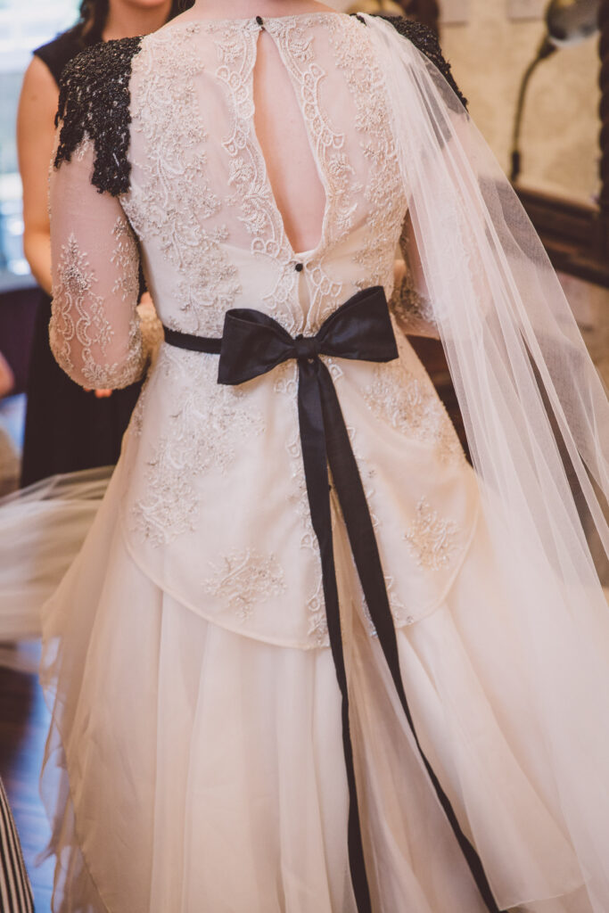 Details of a wedding dress with a black bow