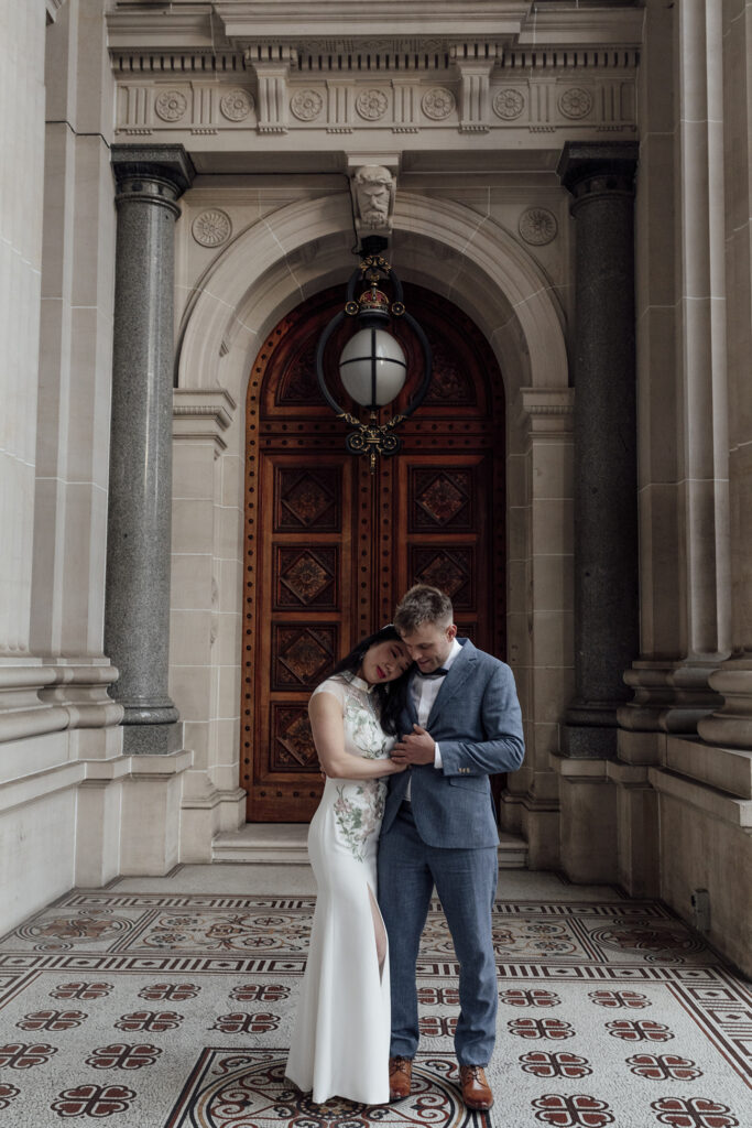 A couple having a Melbourne Elopement, snuggling at Parliament Steps.