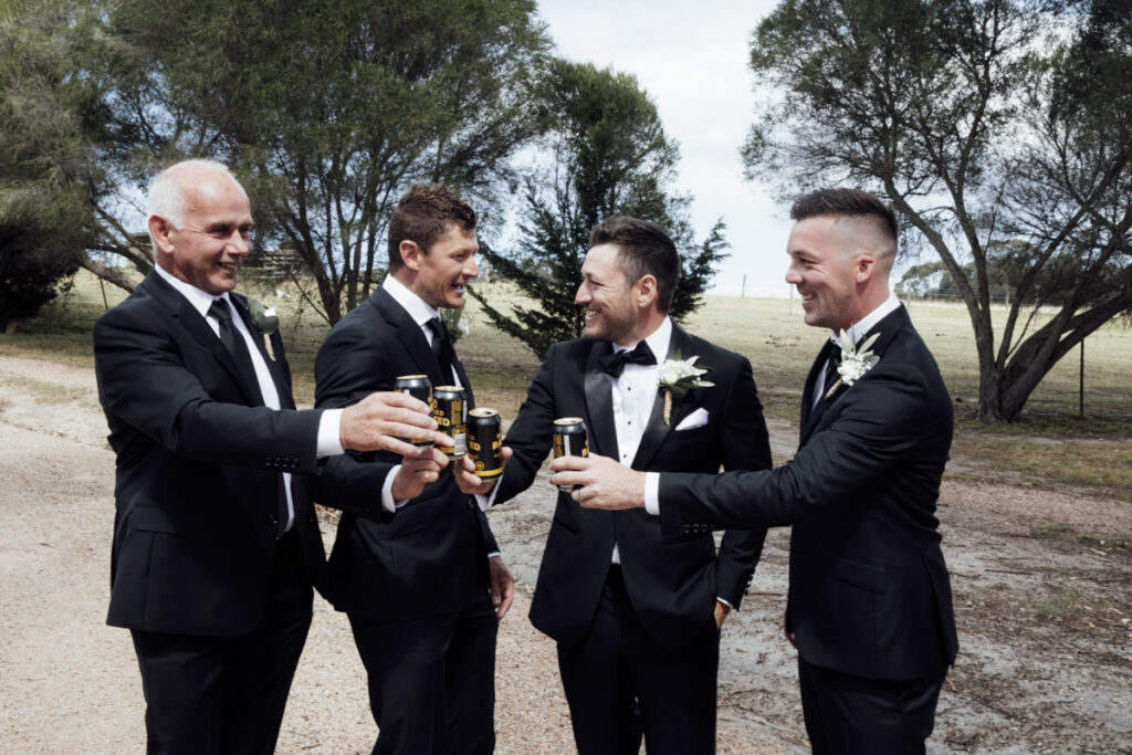 A colour image of the groom and his groomsmen getting ready, they are wearing black tuxedos at his wedding in Eight Acres in Lakes Entrance.