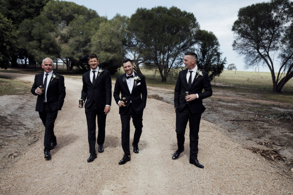 A colour image of the groom and his groomsmen getting ready, they are wearing black tuxedos at his wedding in Eight Acres in Lakes Entrance.