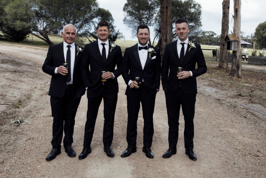 A colour image of the groom and his groomsmen getting ready, they are wearing black tuxedos at his wedding in Eight Acres in Lakes Entrance.