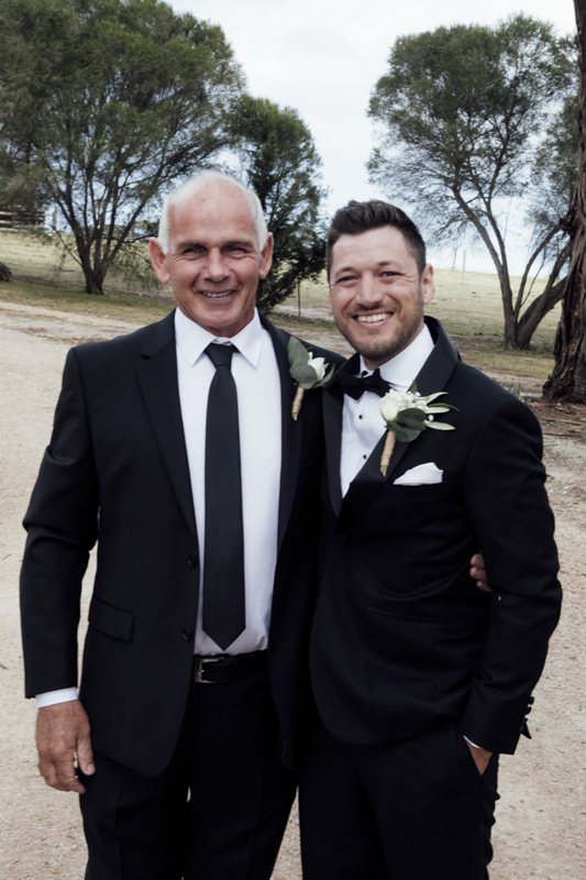 A colour image of the groom and his groomsmen getting ready, they are wearing black tuxedos at his wedding in Eight Acres in Lakes Entrance.