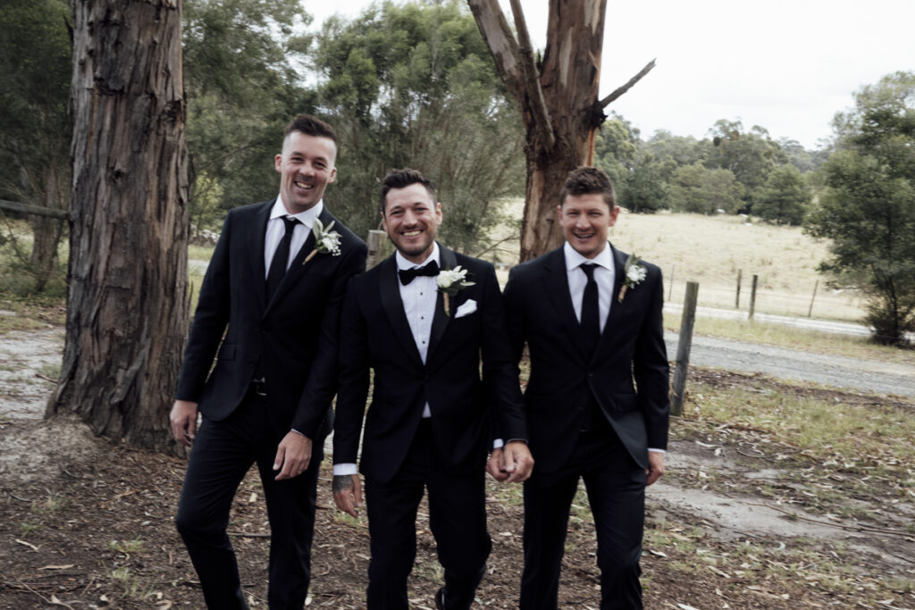 A colour image of the groom and his groomsmen getting ready, they are wearing black tuxedos at his wedding in Eight Acres in Lakes Entrance.