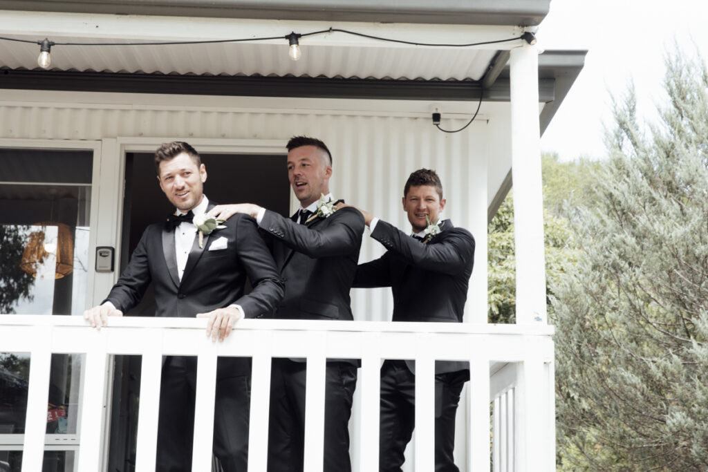 A colour image of the groom and his groomsmen getting ready, they are wearing black tuxedos at his wedding in Eight Acres in Lakes Entrance.