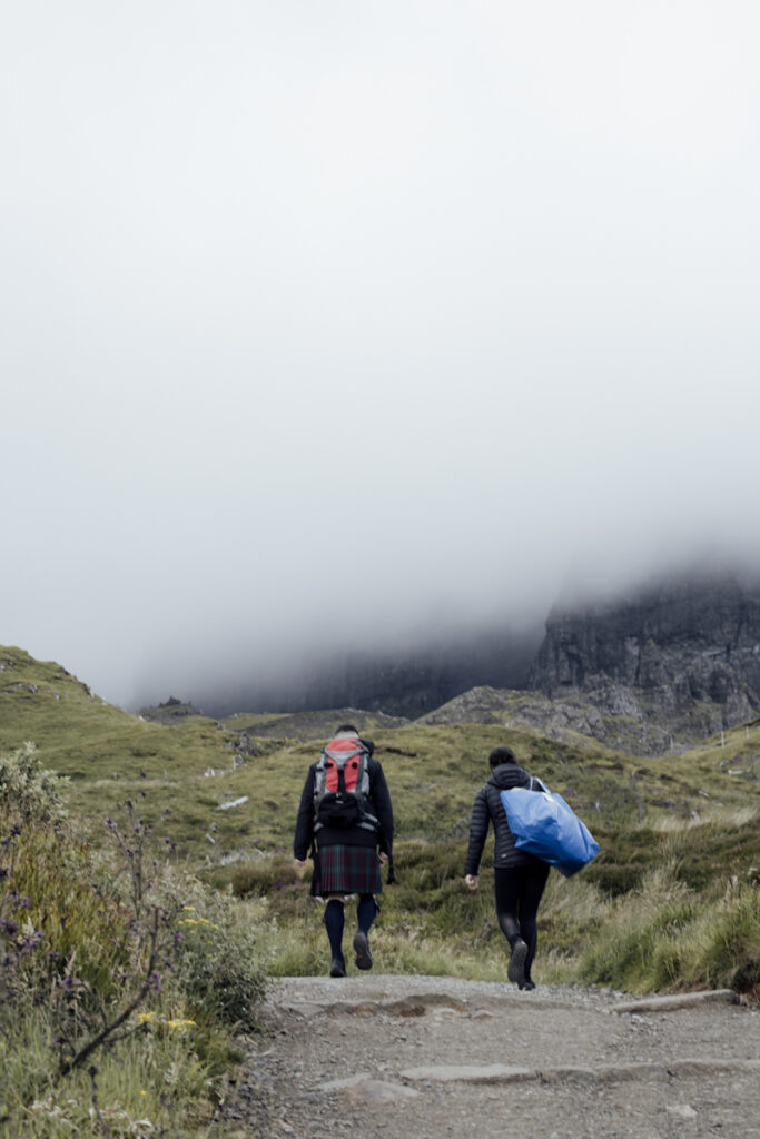 Embracing Adventure as a Scotland wedding photographer. a couple climbing up old man of storr about to elope.