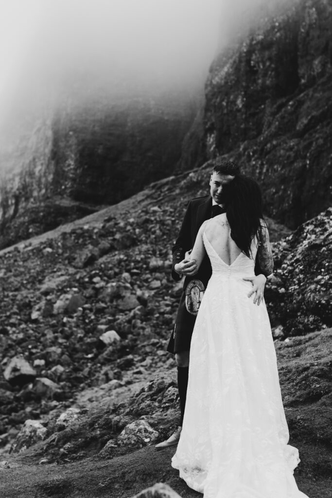 Embracing Adventure as a Scotland wedding photographer. A couple having Black and white wedding photos as they elope up Old man of Storr in Skye