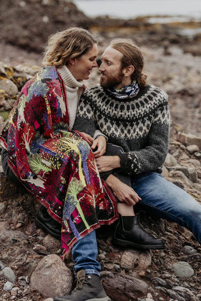 A couple having photos taken at Dunnotter Castle in Scotland. She is wearing an origional Helen Ruth Scarf
