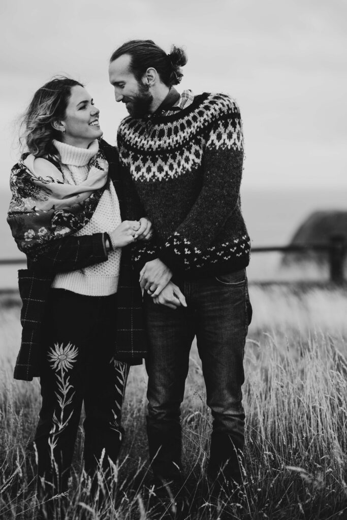 A couple having black and white photos taken at Dunnotter Castle in Scotland. She is wearing an original Helen Ruth Scarf