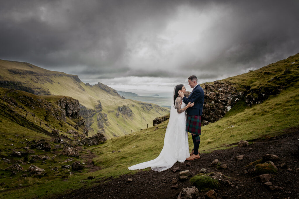 a bride and groom standing on the old man of Storr on the Isle of skye having wedding photos.