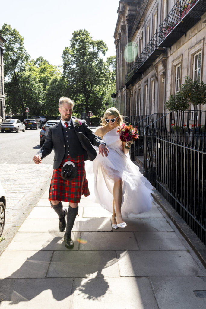 Edinburgh wedding photographer candid, a bride and groom having wedding photos taken on the streets of Edinburgh