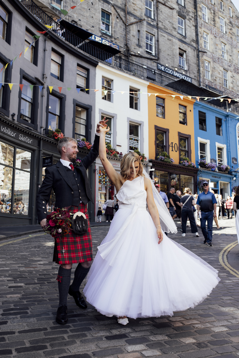 a Couple dancing on the grassmarket in Edinburgh on their wedding day