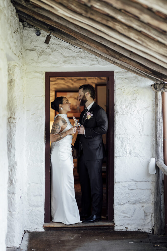 black and white image, bride and groom standing in a door way at Emu Bottom Homestead. Macedon Ranges wedding photography. Sunbury wedding photographer