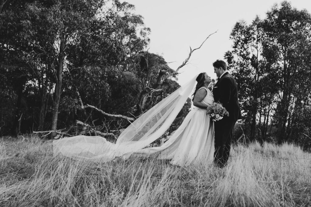 Macedon Ranges wedding photography. Bride and groom in a black and white image on top of a hill overlooking Macedon Ranges.