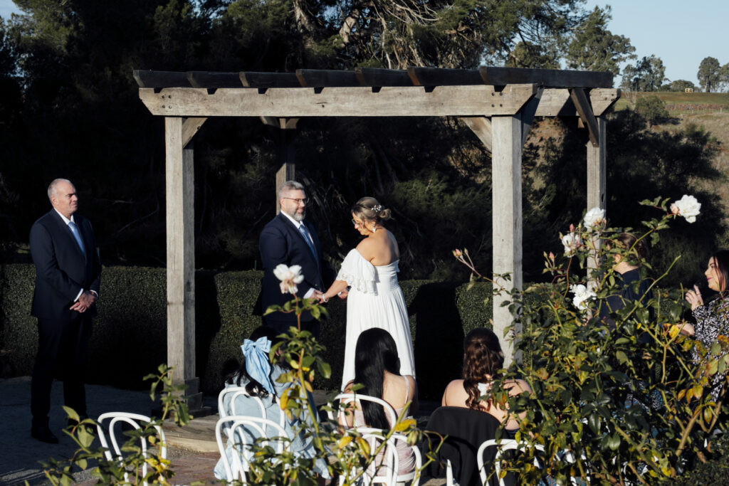 Warrawong estate wedding. Macedon Ranges Wedding photographer. Bride and Groom standing at alter laughing