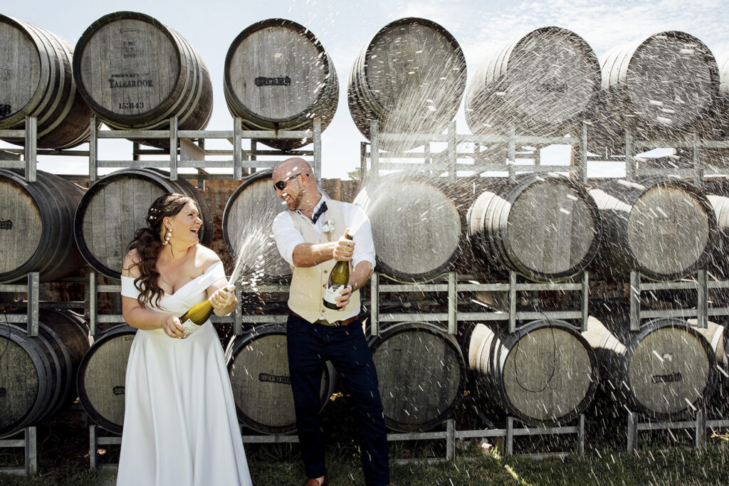 Witchmont estate wedding. a Bride and groom doing a champagne spray.