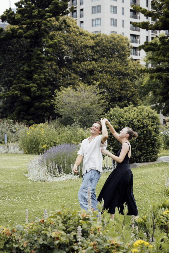 Carlton Gardens proposal. Melbourne Proposal photography. A Proposal in Melbourne. Proposal Photographer. Engagement photographer in Melbourne. a Young couple laughing and holding hands. Candid Documentary Photography 