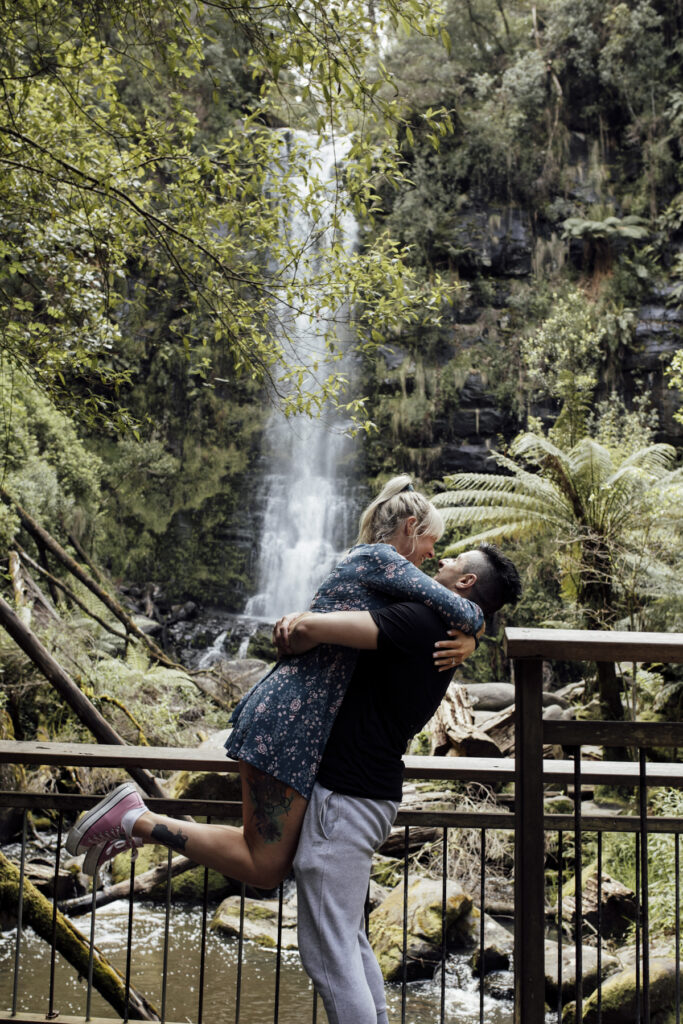 Melbourne Proposal Photography a young fun couple hugging at Erskine Falls on Great Ocean road