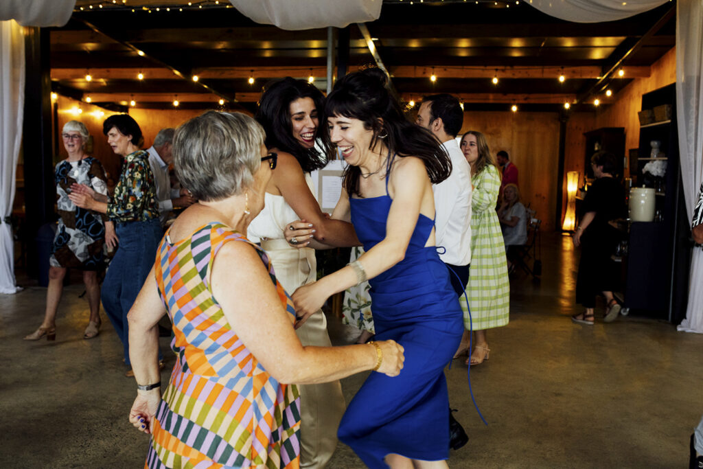 A wedding reception at Gurneys' cider, people are laughing and dancing.