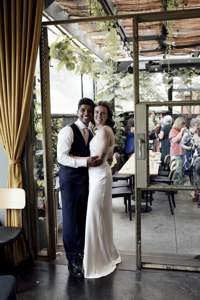 The village Grae Kew. The Magic of a Wine Bar Wedding in Melbourne. Melbourne wedding photographer. candid wedding photography. Intimate wedding venue. A couple having a portrait taken snuggly and close
