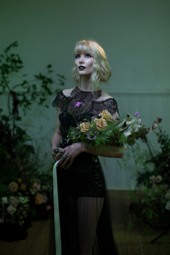 a bride standing in the bluestone chapel at Scrub Hill on her wedding day, she is an alternive bride wearing a stunning black dress from Gwendolyn in Melbourne. She is more moody and alterniteve the photohas a greenish hue.
