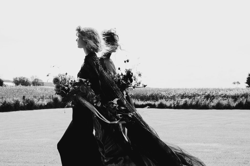 A black and white wedding photo at Scrub Hill. The wedding photo is of two brides, the image is slightly blurred to depict movement.