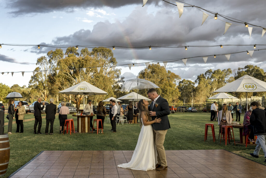 A bride and groom captured under a rainbow at DV Cider after a rainstorm.