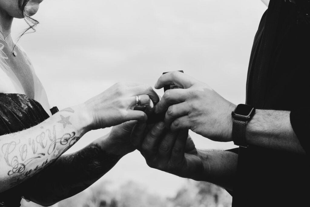 close up of hands exchanging wedding rings at DV Cider