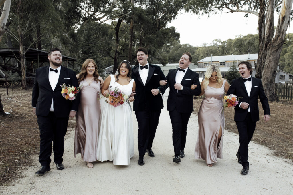 a fun bridal party wedding photo at Paramoor winery, they are all walking down the drivaway laughing and having fun.